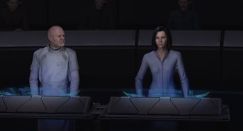 Movie still from “Final Fantasy: The Spirits Within” (2001), directed by Hironobu Sakaguchi – A man and a woman are standing in front of computer monitors; Medium shot, Over the shoulder angle