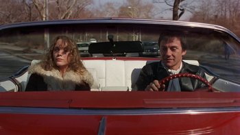 Movie still from “Fingers” (1978), directed by James Toback – A man and a woman sitting in the back of a red car; Medium shot, Low angle