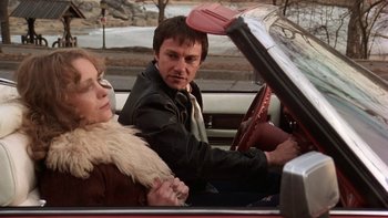 Movie still from “Fingers” (1978), directed by James Toback – A man and a woman driving a car in the street; Medium shot, Low angle