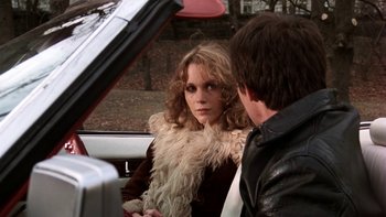 Movie still from “Fingers” (1978), directed by James Toback – A woman sitting in the back of a car next to a man; Close Up shot, Over the shoulder angle
