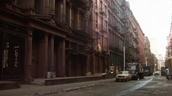 Movie still from “Fingers” (1978), directed by James Toback – An old car parked on the side of the street; Extreme Wide shot, High angle