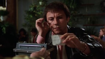 Movie still from “Fingers” (1978), directed by James Toback – A man in a leather jacket holding a piece of paper; Close Up shot, Low angle