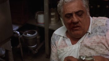 Movie still from “Fingers” (1978), directed by James Toback – An older man with a knife in his mouth; Close Up shot, Low angle
