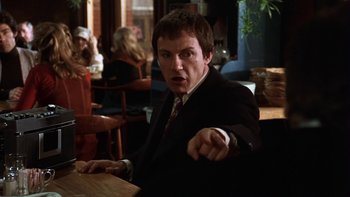 Movie still from “Fingers” (1978), directed by James Toback – A man in a suit and tie pointing at the camera; Medium shot, Low angle