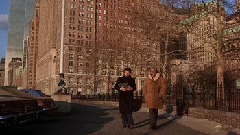 Movie still from “Fingers” (1978), directed by James Toback – Two women are walking on the sidewalk in front of a tall building; Wide shot, Low angle