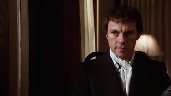 Movie still from “Fingers” (1978), directed by James Toback – A person wearing a suit and tie; Close Up shot, Low angle