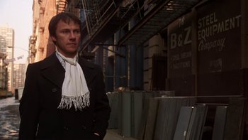 Movie still from “Fingers” (1978), directed by James Toback – A man wearing a black jacket and a white scarf; Medium shot, Low angle