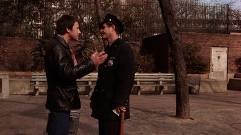 Movie still from “Fingers” (1978), directed by James Toback – Two men talking to each other outside in a park; Medium shot, Over the shoulder angle