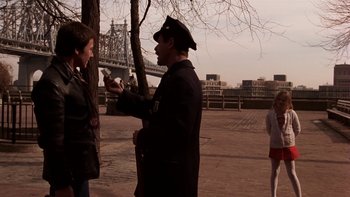 Movie still from “Fingers” (1978), directed by James Toback – A man in a police uniform talking on a cell phone; Medium shot, Over the shoulder angle