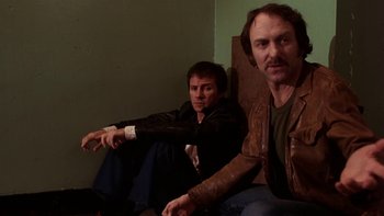 Movie still from “Fingers” (1978), directed by James Toback – A couple of men sitting next to each other in a room; Medium shot, Low angle