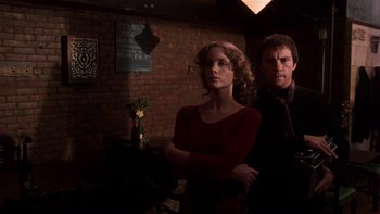 Movie still from “Fingers” (1978), directed by James Toback – A man and a woman standing next to each other in a room; Medium shot, Low angle