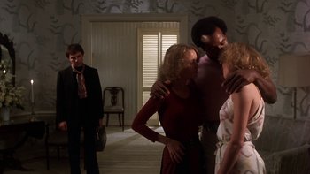 Movie still from “Fingers” (1978), directed by James Toback – A group of people standing in a living room; Medium shot, Low angle