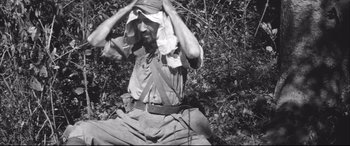 Movie still from “Fires on the Plain” (1959), directed by Kon Ichikawa – An old photo of a man holding his hands to his face; Medium shot, High angle