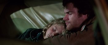 Movie still from “Firestarter” (1984), directed by Mark L. Lester – A man and a little girl sleeping on a couch; Close Up shot, High angle