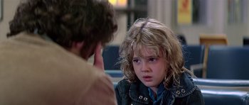 Movie still from “Firestarter” (1984), directed by Mark L. Lester – A young girl sitting in front of a man; Close Up shot, Over the shoulder angle