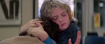 Movie still from “Firestarter” (1984), directed by Mark L. Lester – A young girl is hugging a younger girl; Close Up shot, Over the shoulder angle