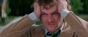 Movie still from “Firestarter” (1984), directed by Mark L. Lester – A person holding his head with his hands; Close Up shot, Low angle