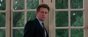 Movie still from “Firestarter” (1984), directed by Mark L. Lester – A person wearing a suit and tie; Close Up shot, Low angle