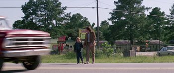 Movie still from “Firestarter” (1984), directed by Mark L. Lester – A man and a child walking down a street; Wide shot, Low angle