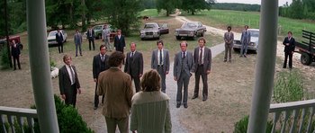 Movie still from “Firestarter” (1984), directed by Mark L. Lester – A group of men in suits and ties standing in a field; Wide shot, High angle