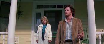 Movie still from “Firestarter” (1984), directed by Mark L. Lester – A man and a woman standing in front of a house; Medium shot, Low angle