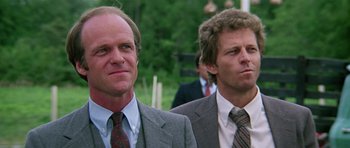 Movie still from “Firestarter” (1984), directed by Mark L. Lester – A couple of men standing next to each other; Close Up shot, Low angle