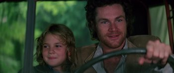 Movie still from “Firestarter” (1984), directed by Mark L. Lester – A man and a little girl sitting next to each other; Close Up shot, Low angle