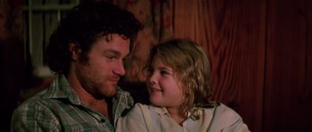 Movie still from “Firestarter” (1984), directed by Mark L. Lester – A man and a little girl sitting next to each other; Close Up shot, Over the shoulder angle