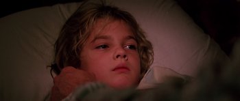 Movie still from “Firestarter” (1984), directed by Mark L. Lester – A little girl laying in a bed with her head on a pillow; Close Up shot, Low angle