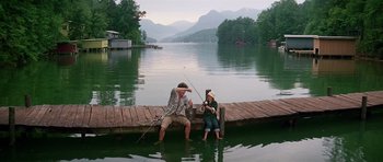 Movie still from “Firestarter” (1984), directed by Mark L. Lester – A man and a boy fishing on a dock; Wide shot, Low angle