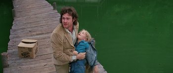 Movie still from “Firestarter” (1984), directed by Mark L. Lester – A man and a little girl walking on a dock; Medium shot, High angle
