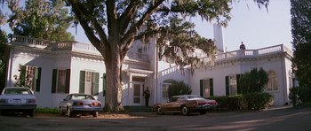 Movie still from “Firestarter” (1984), directed by Mark L. Lester – A man standing in front of a large white building; Extreme Wide shot, Low angle