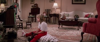Movie still from “Firestarter” (1984), directed by Mark L. Lester – A young girl sitting on the floor in a living room; Wide shot, High angle