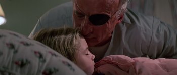 Movie still from “Firestarter” (1984), directed by Mark L. Lester – An old man and a young girl are kissing; Close Up shot, Low angle