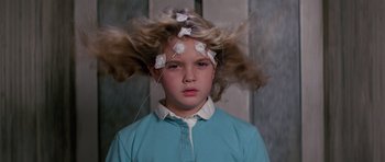 Movie still from “Firestarter” (1984), directed by Mark L. Lester – A young girl with hair stuck to her head; Close Up shot, Low angle