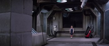 Movie still from “Firestarter” (1984), directed by Mark L. Lester – A little girl standing next to a camera in a room; Wide shot, High angle