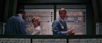 Movie still from “Firestarter” (1984), directed by Mark L. Lester – A man and a woman standing next to each other in front of an electrical panel; Medium shot, Low angle