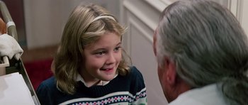 Movie still from “Firestarter” (1984), directed by Mark L. Lester – A little girl smiling at an older gentleman; Close Up shot, Over the shoulder angle
