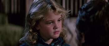 Movie still from “Firestarter” (1984), directed by Mark L. Lester – A young girl with blonde hair sitting in a room; Close Up shot, Over the shoulder angle