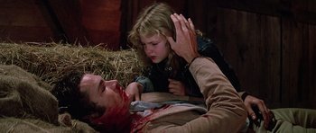 Movie still from “Firestarter” (1984), directed by Mark L. Lester – A young girl holding a knife over a man's face; Medium shot, High angle