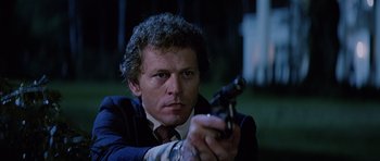 Movie still from “Firestarter” (1984), directed by Mark L. Lester – A person holding a gun; Close Up shot, Low angle