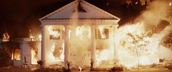Movie still from “Firestarter” (1984), directed by Mark L. Lester – A house on fire with a lot of smoke coming out of it; Extreme Wide shot, Low angle