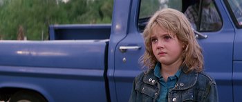 Movie still from “Firestarter” (1984), directed by Mark L. Lester – A little girl standing in front of a blue truck; Close Up shot, Low angle