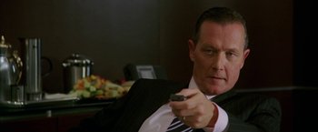 Movie still from “Firewall” (2006), directed by Richard Loncraine – A person holding a tv remote; Close Up shot, High angle