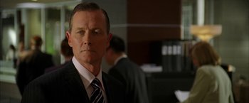 Movie still from “Firewall” (2006), directed by Richard Loncraine – A person wearing a suit and tie; Close Up shot, Over the shoulder angle