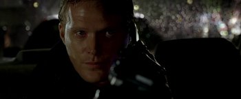 Movie still from “Firewall” (2006), directed by Richard Loncraine – A person holding a gun; Close Up shot, Over the shoulder angle