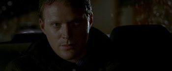 Movie still from “Firewall” (2006), directed by Richard Loncraine – A person wearing a suit and tie; Close Up shot, Over the shoulder angle