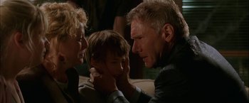 Movie still from “Firewall” (2006), directed by Richard Loncraine – A man and a woman and a child in front of a couch; Close Up shot, Over the shoulder angle