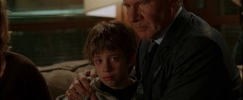 Movie still from “Firewall” (2006), directed by Richard Loncraine – An older man and a young boy sitting next to each other; Close Up shot, Over the shoulder angle