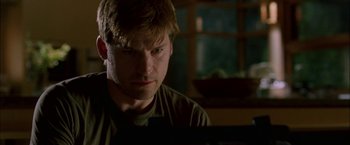 Movie still from “Firewall” (2006), directed by Richard Loncraine – A man sitting in front of a computer monitor; Close Up shot, Low angle